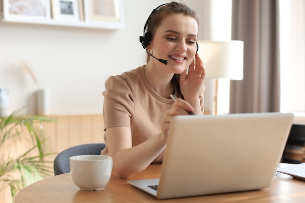 Freelance operator talking with headsets and consulting clients from home office.