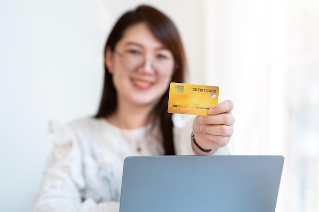 Freelance people business female casual Abstract blur with focus on show holding a credit card working with laptop computer in coffee shop like the backgroundfor online shopping and payment