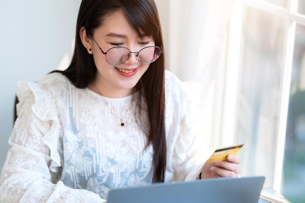 Freelance people business female casual show holding a credit card working with laptop computer in coffee shop like the backgroundfor online shopping and payment via internet