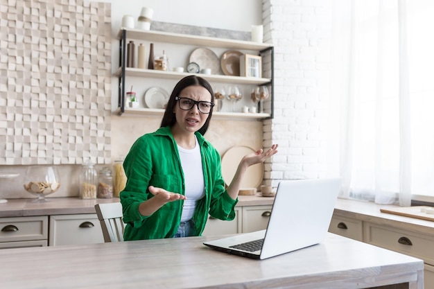 Freelance work at home confused young beautiful woman in glasses and green clothes freelancer