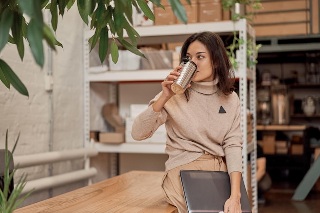 Freelancer leaning on table and drinking coffee