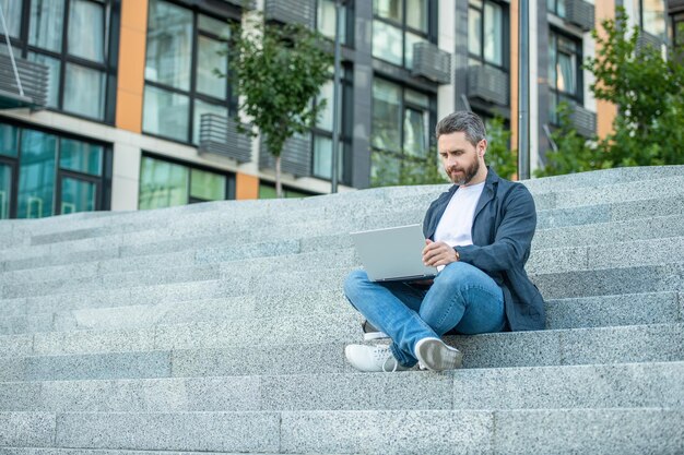 Freelancer man with laptop outdoor copy space freelancer man in the street