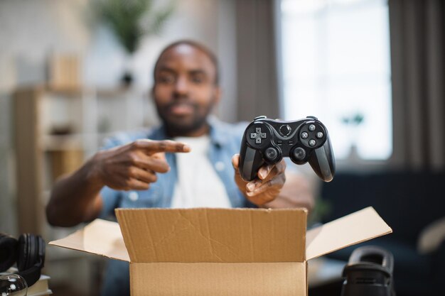 Freelancer unpacking new parcel with wireless joystick