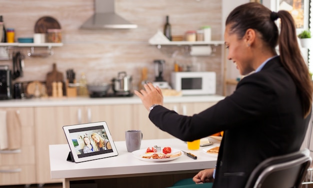 Freelancer during a video call with sister while eating breakfast