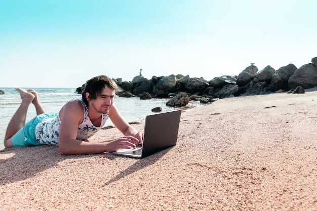 Freelancer with a laptop works on a beach