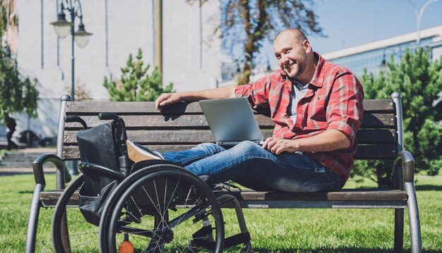 Freelancer with a physical disability who uses wheelchair working at the park