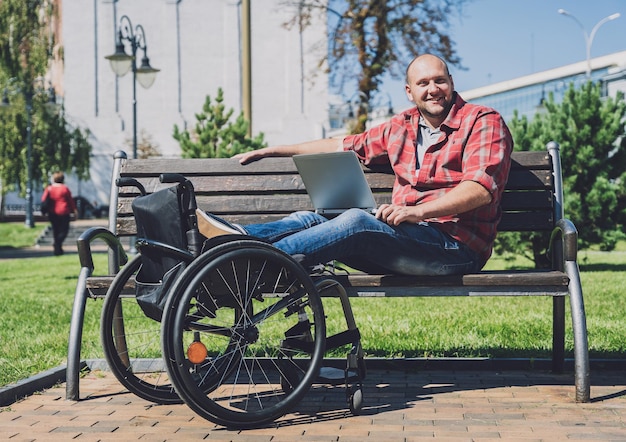 Freelancer with a physical disability who uses wheelchair working at the park