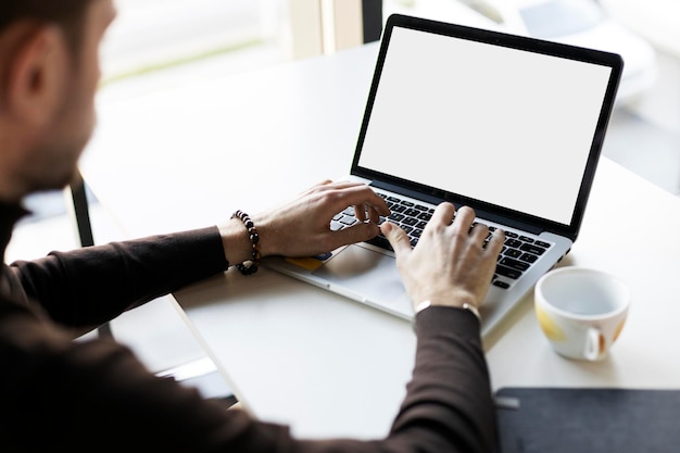 Freelancer worker using laptop tipping working on online project sitting at workplace