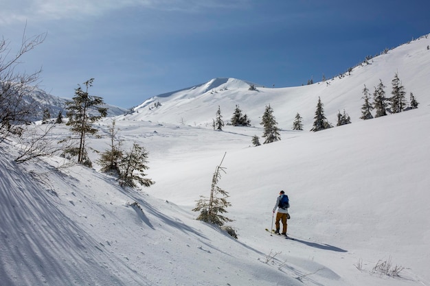 A freerider on skis makes his ascent eager for the adrenalinefueled ride ahead