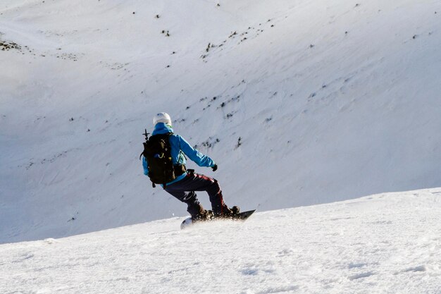 Freerider snowboarder going down the slope