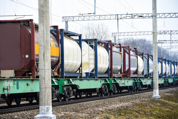 The freight railroad train travels along the railway tracks