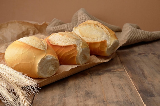 french bread with wheat on wooden table