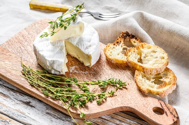 French Brie cheese with grapes. White background. Top view.