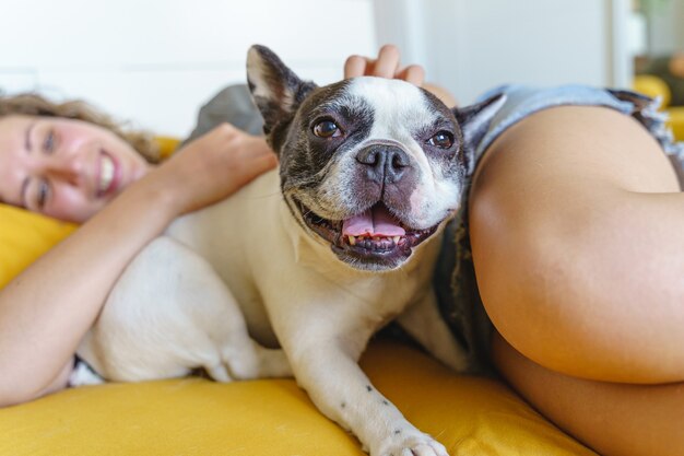 french bulldog isolated at home with unrecognizable owner. side view of dog smiling in bed.