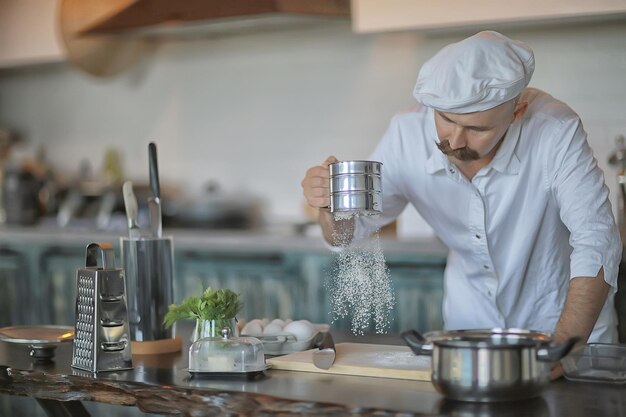 french chef in the kitchen preparing food, cooking, haute cuisine, man with mustache