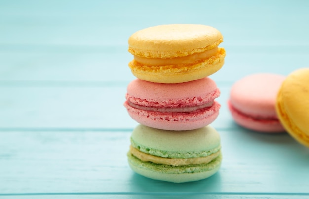 French colorful macarons on blue background. Space for text