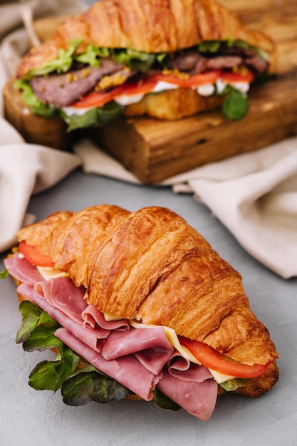 French croissant sandwich with lettuce cheese tomatoes and ham