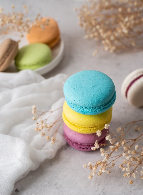 Photo french dessert colorful macaroons on the table, decorated with flowers and tablecloth