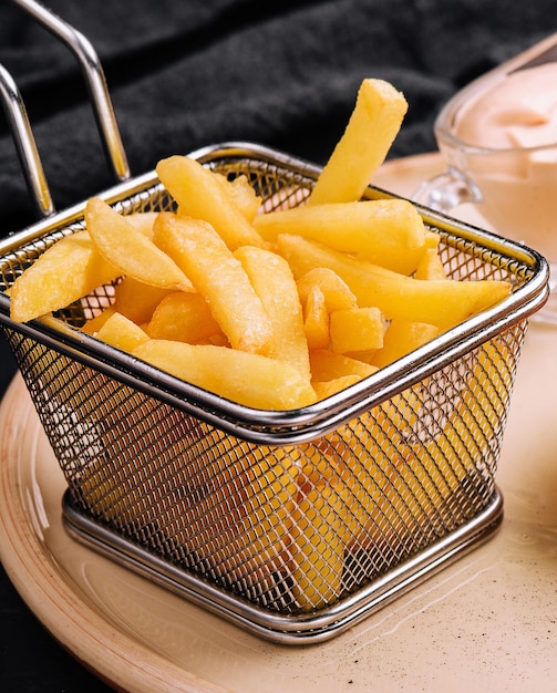 French fries in metal wire basket isolated