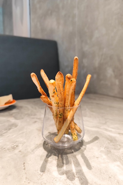 French fries or noodles are served in a glass at a restaurant table