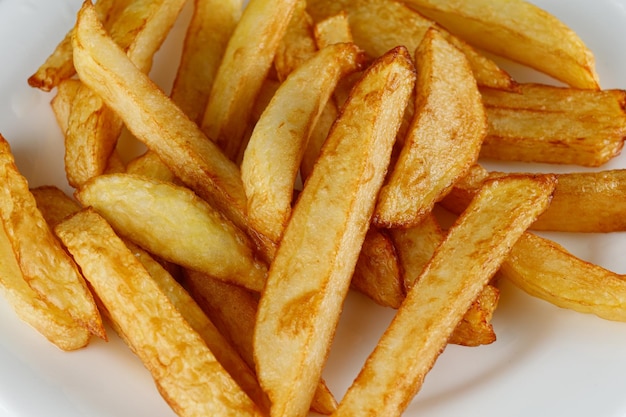 French fries on a white plate Potatoes fries in the plate isolated on black