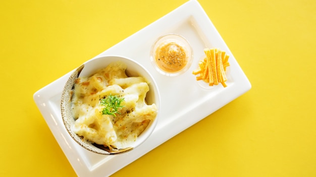 french fries with cheese on a yellow table.