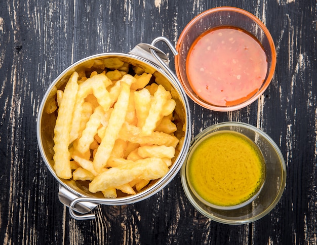 French fries with ketchup on wooden surface.