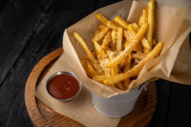 French fries with tomato sauce on a dark wooden table