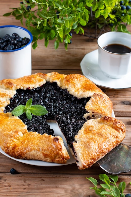 French galette or pie with blueberry on a wooden serving board on a culinary background Summer homemade sweet pastries