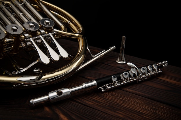 French horn and a flute on a wooden table