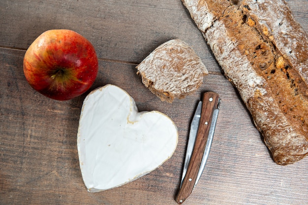 French Neufchatel cheese shaped heart on a wooden surface