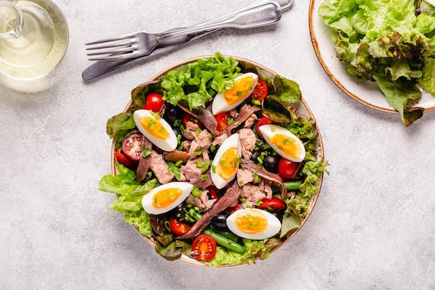 French salad Nicoise with tuna eggs green beans tomatoes olives lettuce and anchovies