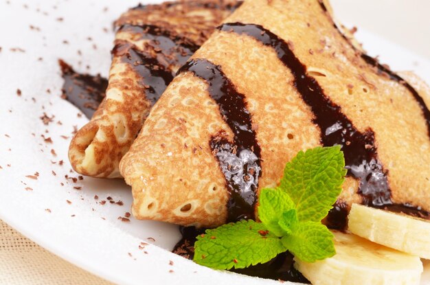 French style crepes with banana, chocolate sauce and sugar powder