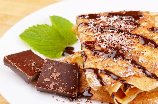 Photo french style crepes with chocolate sauce and sugar powder