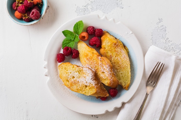 French sweet toasts with berries. Old gray vintage table. Top view. Copy space.