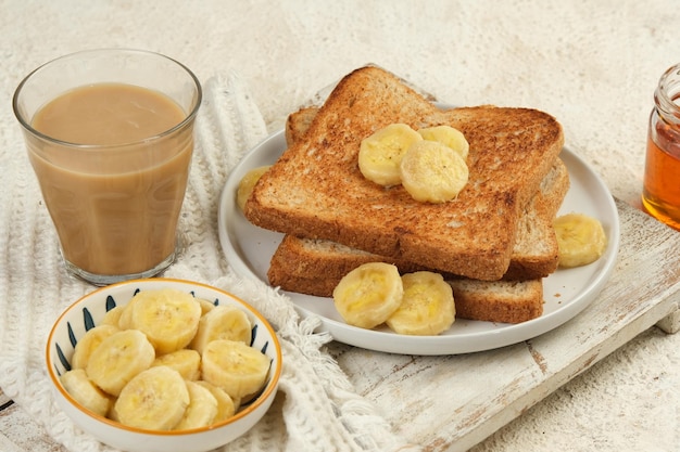 Photo french toast with banana and honey on white background