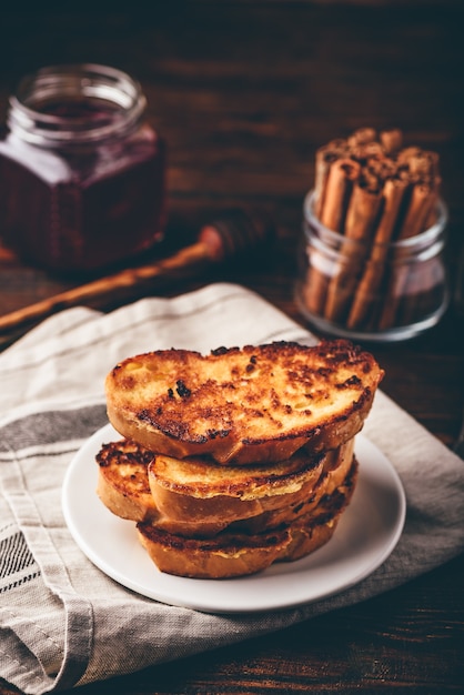 French toasts on white plate over wooden surface