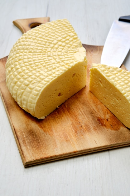 Fresh Adyghe cheese on wooden cutting board