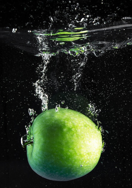 Fresh apple falling in water