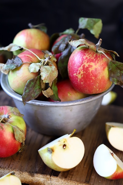 Fresh apples in a bowl on a wooden surface