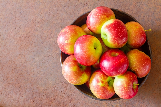 Fresh apples on a metal plate against a rusty metal surface. Top view. Closeup, selective focus