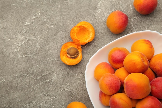 Fresh apricots in the bowl on grey concrete background