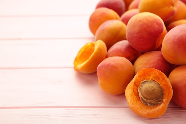 Fresh apricots on a pink wooden background Space for text