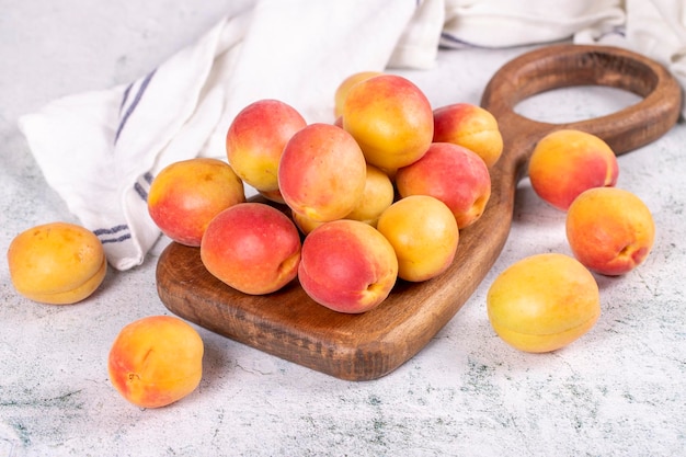 Fresh apricots Ripe apricots in wooden serving platter on stone background Bulk apricots close up