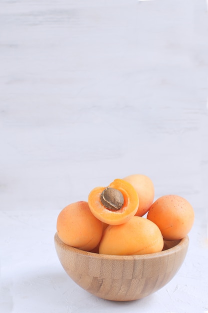 Fresh apricots in white bamboo bowl Summer seasonal fruit  Harvesting Organic fruits Isolated White 