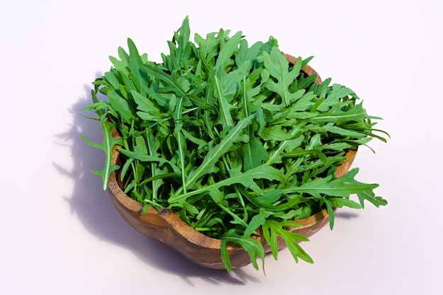 Fresh arugula leaves in a wooden bowl