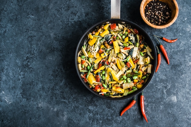 Fresh asian vegetables mix, Thai wok in a black pan on the blac