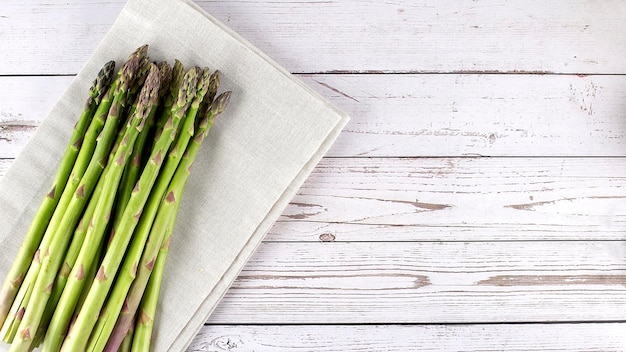 Fresh asparagus on napkin on a wood table Copy space