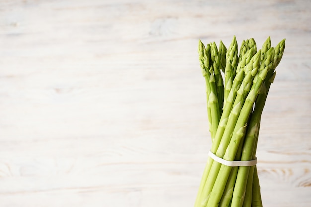 Fresh asparagus on wooden surface, space for text.