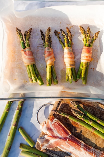 Fresh asparagus wrapped in bacon prepared to fry